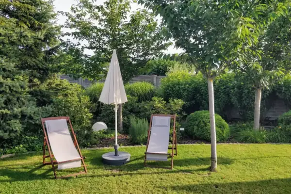 Tuin met gazon, ligstoelen en borders, tuinaanleg in Amsterdam
